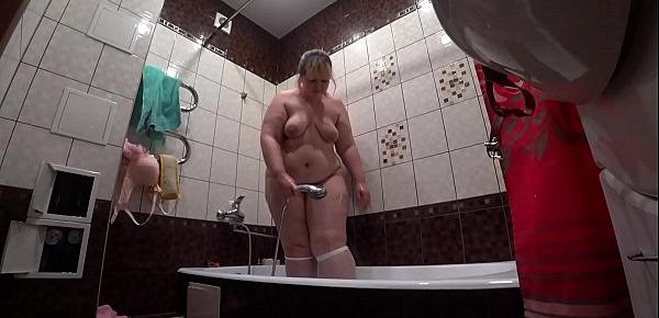  Behind the scenes, a hidden camera is spying on a fat porn model with a big ass in the bathroom.